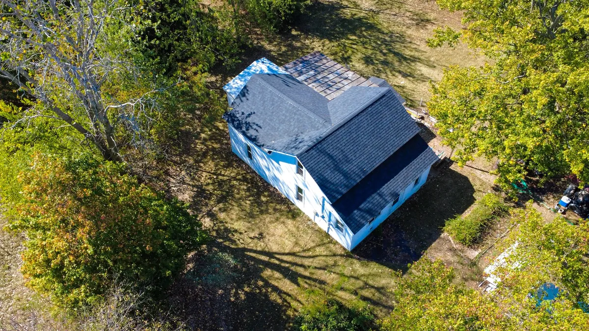 Farmhouse in Northwest Ohio with emergency tarp covering storm-damaged roof area