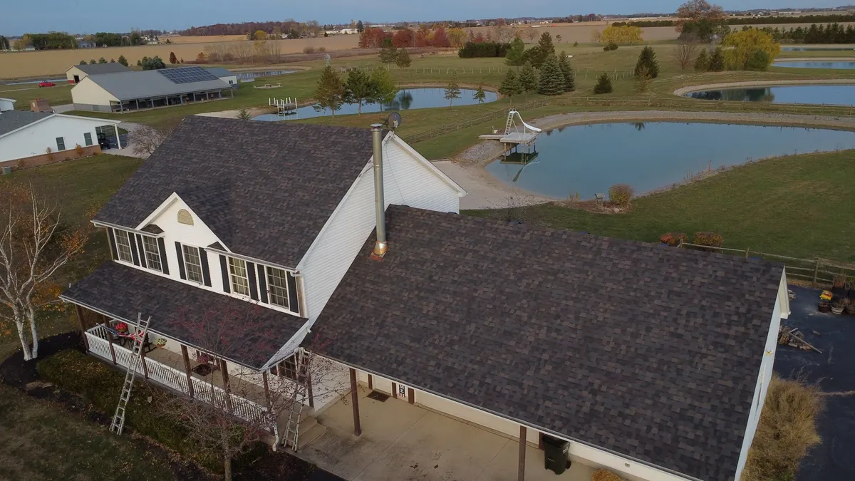 Farmhouse with metal roof beside a pond in rural Northwest Ohio