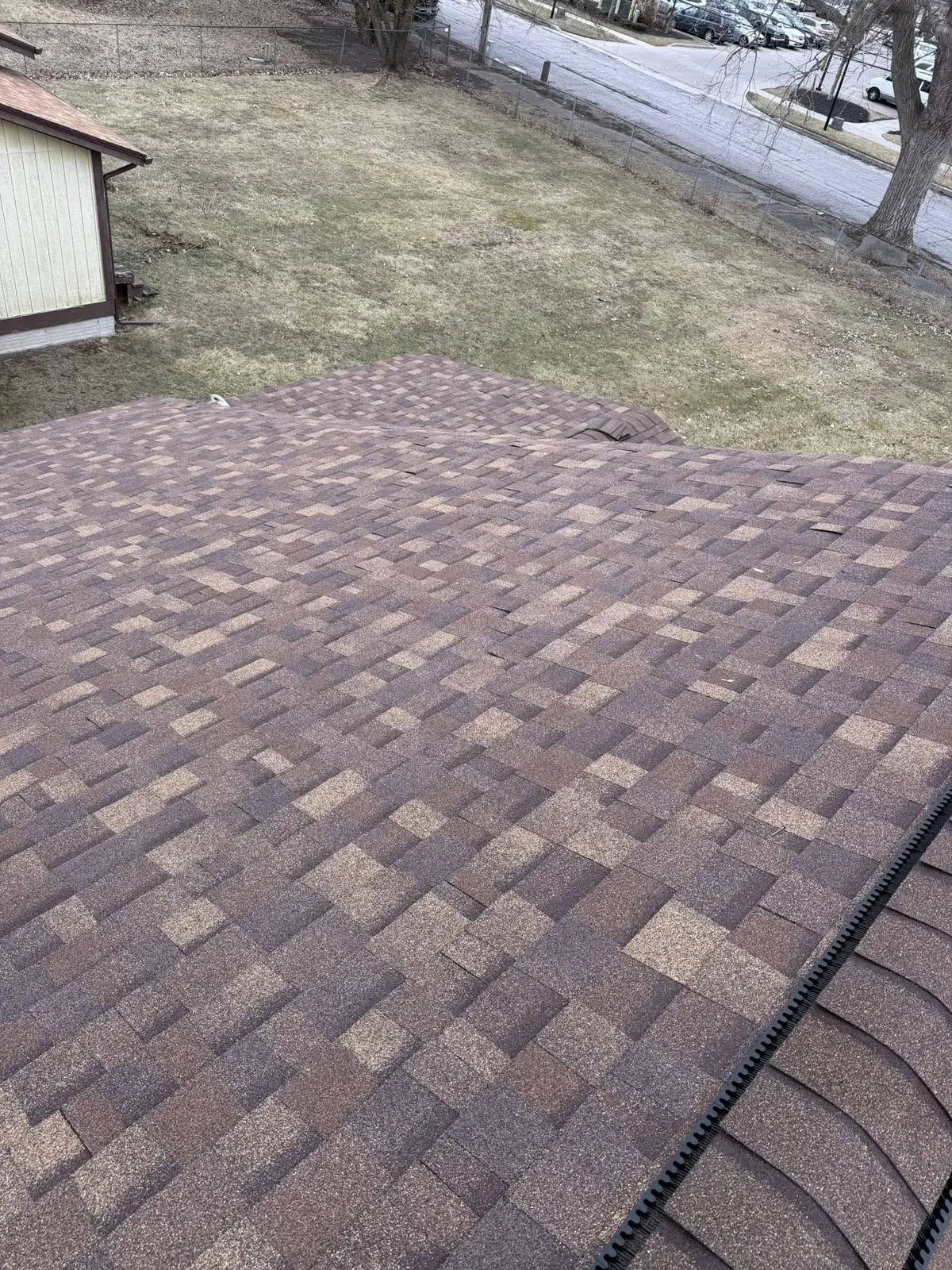 Overhead view of asphalt shingle roof showing granule loss and wear patterns