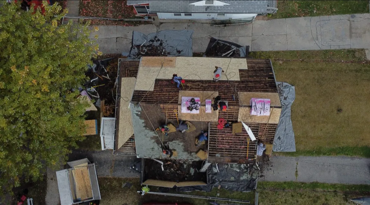Big Horn Roofing crew performing a full tear-off after storm damage in Northwest Ohio, aerial view