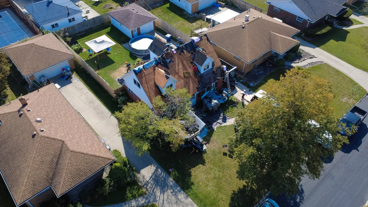 Aerial view of a suburban roof tear-off and replacement project in Northwest Ohio